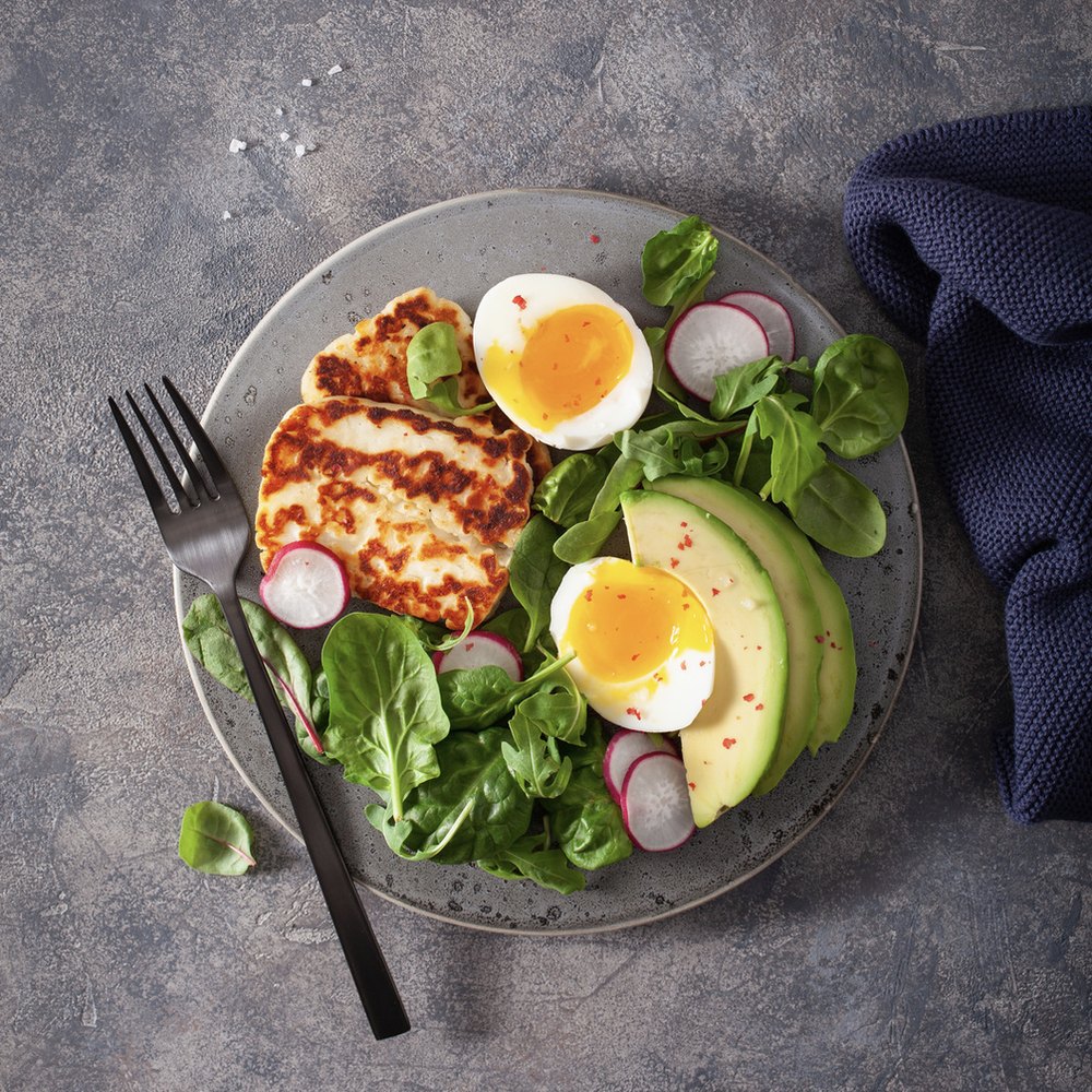 Bord met gegrilde halloumi, avocado, radijs en ei